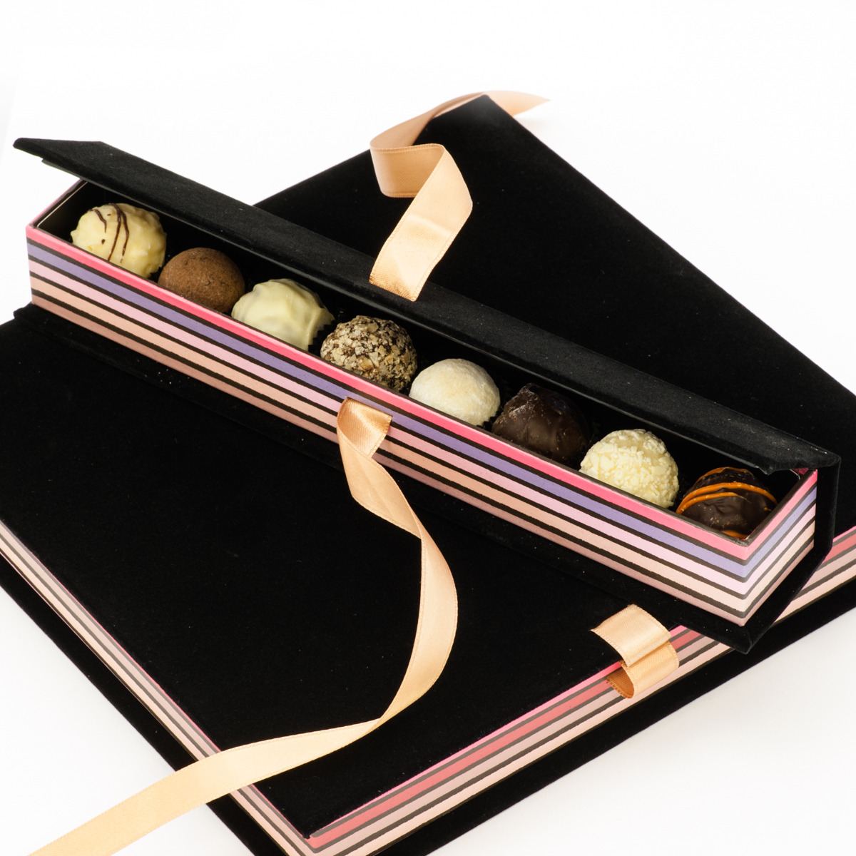 A small-size Chocobong truffle presentation box, filled with an assortment of Belgian truffles, resting atop a large-sized presentation box.